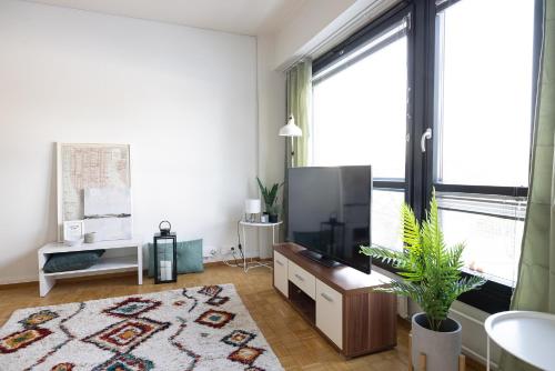 a living room with a tv and a large window at 2ndhomes Mikonkatu Apartment 3 in Helsinki