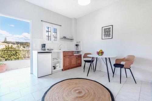 a kitchen with a table and chairs and a window at Elena-Stella Apartments Arillas Corfu in Arillas
