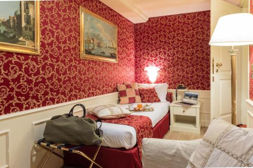 a bedroom with red wallpaper and a bed in a room at Duodo Palace in Venice