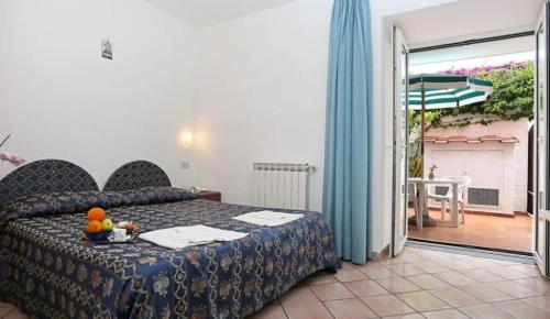 een slaapkamer met een bed en een balkon met een patio bij Hotel Residence S.Angelo in Ischia