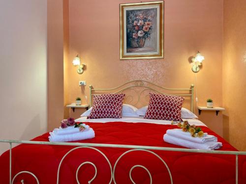 - une chambre avec un lit rouge et 2 oreillers dans l'établissement Appartamento La Sicula, à Realmonte
