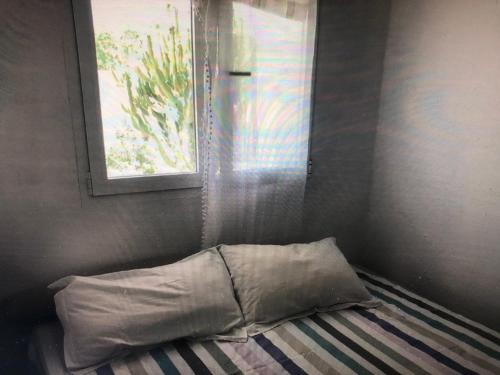 Cama con almohada en habitación con ventana en apartamento en Almería