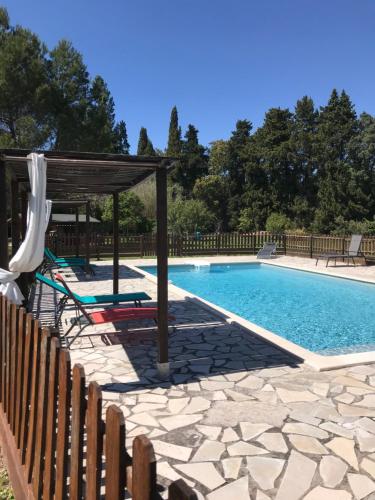 une piscine avec un kiosque et une piscine dans l'établissement Le Mas Mérindol Gîte Ventoux, à Loriol-du-Comtat
