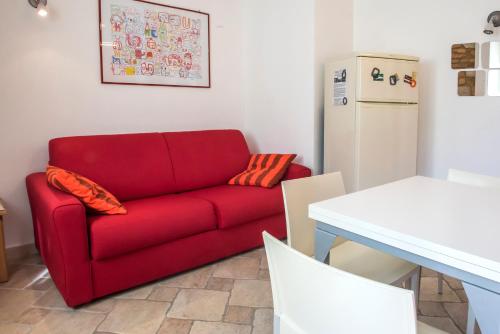 a red couch in a kitchen with a refrigerator at A07 - Poggio, delizioso bilocale con portico in Poggio
