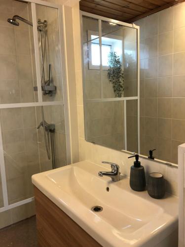 a bathroom with a sink and a shower with a mirror at Vakantiewoning aan het water in Råda