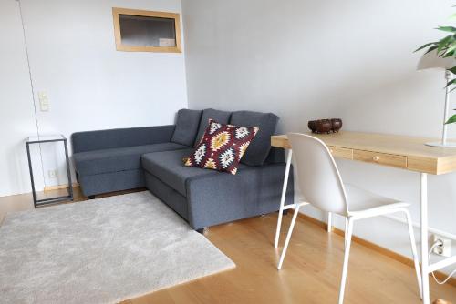 a living room with a blue couch and a table at 2ndhomes Premium 1BR apartment with Sauna and Balcony in Kamppi Center in Helsinki