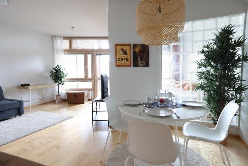 a living room with a white table and chairs at 2ndhomes Premium 1BR apartment with Sauna and Balcony in Kamppi Center in Helsinki