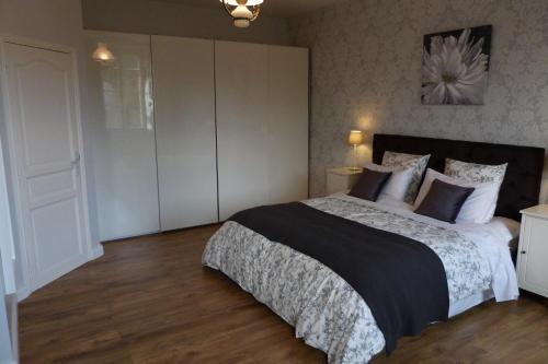 a bedroom with a bed with a black and white comforter at Logis de L'Arceau in Celles