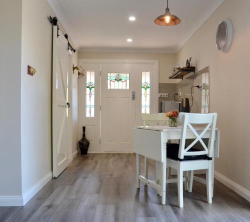 a kitchen with a white table and a white chair at The stables in Wandin North