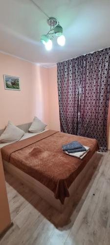 una camera da letto con un letto con un piumone rosso di Гостиница ОАЗИС a Atyraū