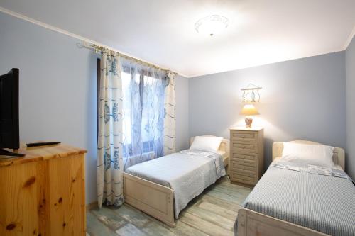 a bedroom with two twin beds and a television at Guest House Soirée in Nesebar