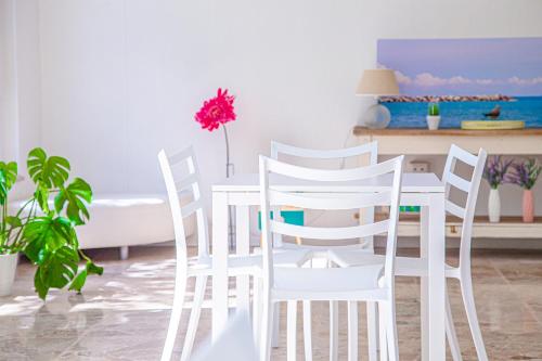 a white dining room with a table and chairs at Hotel Rio Beach & Breakfast in Cesenatico