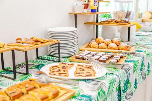 a table topped with plates of pastries and breads at Hotel Rio Beach & Breakfast in Cesenatico