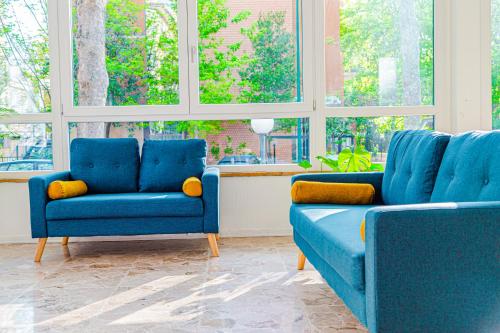 two blue chairs in a room with windows at Hotel Rio Beach & Breakfast in Cesenatico