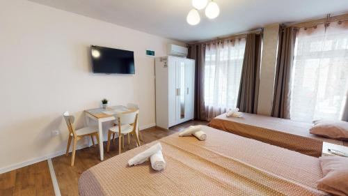 Un dormitorio con 2 camas y una mesa con comedor. en Markoni 4, en Burgas