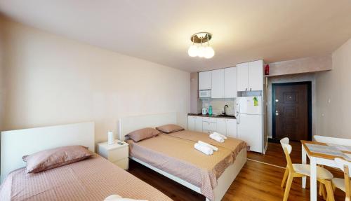 1 dormitorio con 2 camas, mesa y cocina en Markoni 4, en Burgas