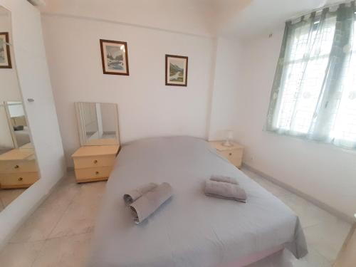- une chambre blanche avec un lit et 2 serviettes dans l'établissement Palais des Iles, à Cannes
