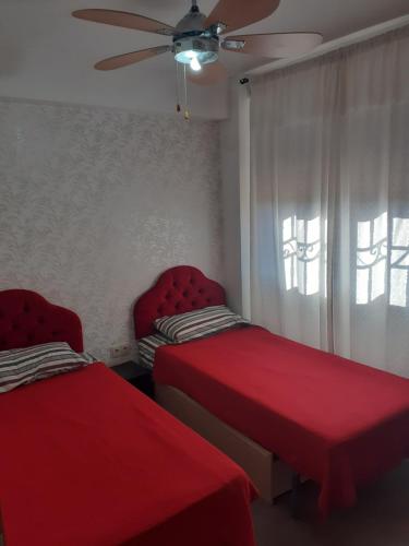 a bedroom with two beds and a ceiling fan at Apartamento en la playa in Torremolinos