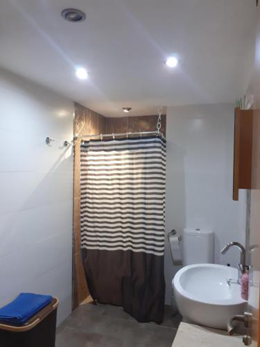 a bathroom with a shower and a tub and a sink at Apartamento en la playa in Torremolinos