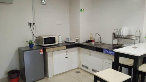 una cucina con lavello e forno a microonde su un bancone di Staycity Apartment - D'Perdana Sri Cemerlang a Kota Bharu