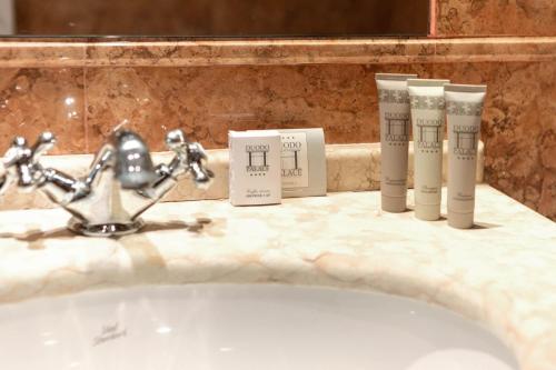 zlew w łazience z 4 produktami na ladzie w obiekcie Duodo Palace w Wenecji