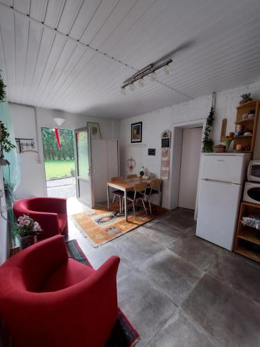 sala de estar con sillas rojas y mesa en Le Petit Dôme, en Bièvre