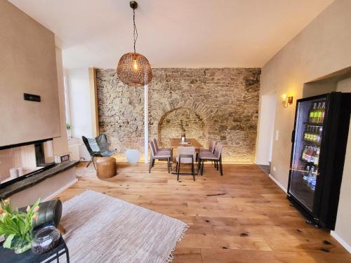 a living room with a table and chairs and a stone wall at Boutique Hotel Marielle in Bad Münstereifel