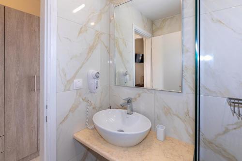 a bathroom with a sink and a mirror at Agapitos Apartments in Nikiti