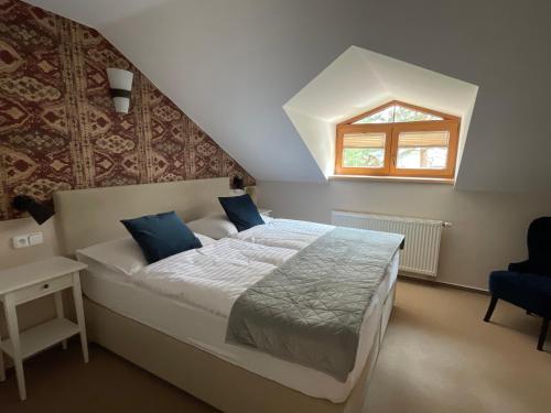 a bedroom with a large bed with a window at Resort-Restaurant Stilec in Kamenný Újezd