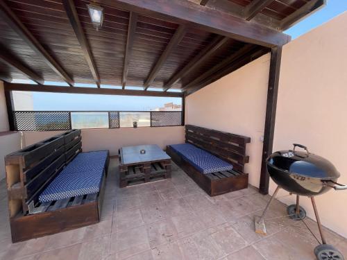 ein Zimmer mit zwei Bänken und einem Grill auf einem Balkon in der Unterkunft Casa Niky 25 in Puerto del Rosario