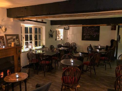 a restaurant with tables and chairs and a chalkboard on the wall at The New Inn Clovelly in Clovelly