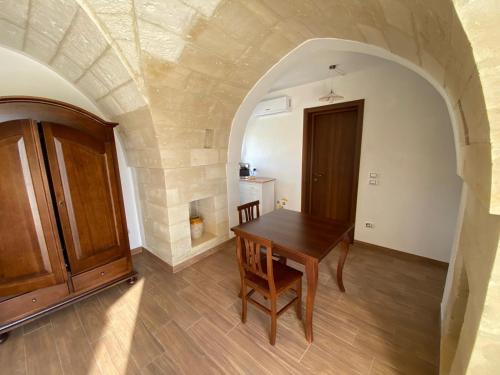 una sala da pranzo con un tavolo di legno e una porta di Uliveto Sant' Isidoro a Maglie