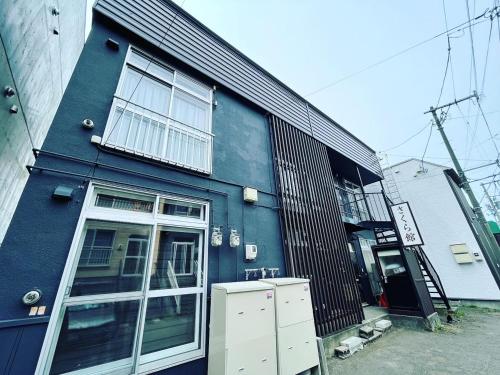 a blue building with a window and a door at 観光や仕事に便利ｻｰﾋﾞｽｱﾊﾟｰﾄﾒﾝﾄ札幌さくら2-2小型犬滞在可能 in Toyohira