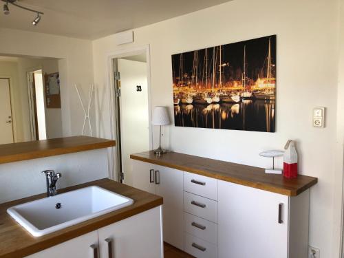 una cocina con fregadero y una pintura en la pared en Apartments in Henån en Henån