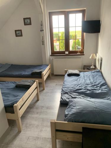 a room with two beds and a window at Pokoje gościnne Ścibórz in Ścibórz