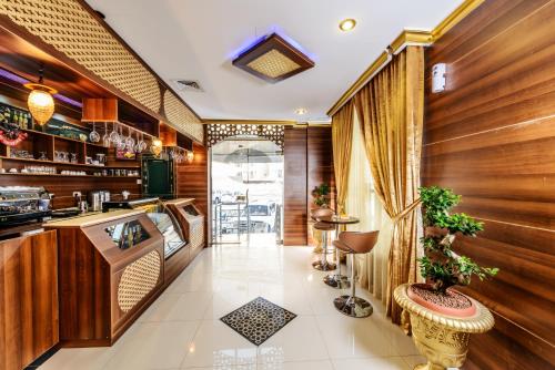a restaurant with wooden walls and a kitchen with a counter at Bravo Royal Hotel Suites in Kuwait
