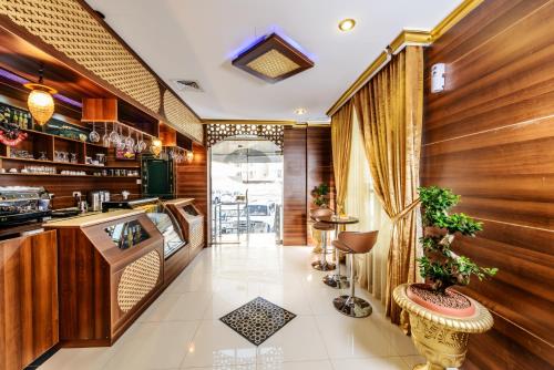 a restaurant with wooden walls and a kitchen with a counter at Bravo Royal Hotel Suites in Kuwait