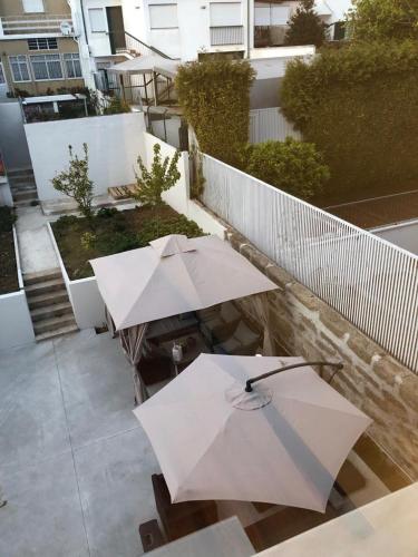 a group of tables with umbrellas on a balcony at Angel by Prada City House in Vila Nova de Gaia