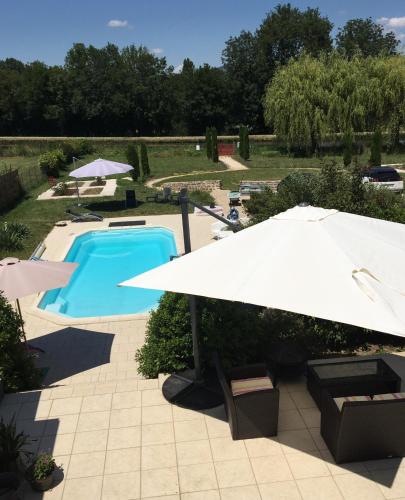 a large white umbrella and a swimming pool with at Calme au Canal de Centre in Dennevy