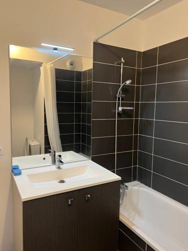 La salle de bains est pourvue d'un lavabo et d'une baignoire. dans l'établissement Résidence neuve le K 10 mn gare, parking , tram, à Montpellier