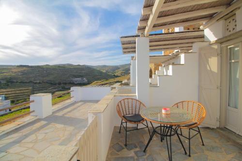 a balcony with a table and chairs and a view at Enea by TinosHost in Tinos Town