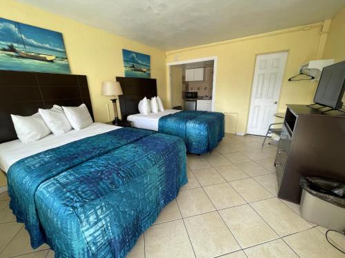 a hotel room with two beds and a television at Sandy Shores Resort in North Wildwood