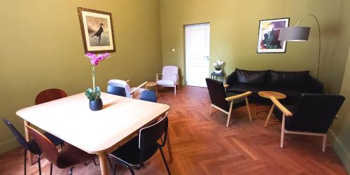 een woonkamer met een tafel en stoelen en een bank bij Histoire de Loire La Gabare in Saumur
