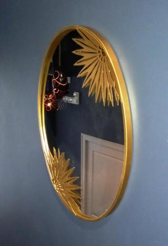 un miroir au design doré sur un mur dans l'établissement Histoire de Loire La Gabare, à Saumur
