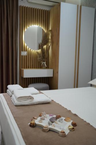 a bedroom with a bed with towels and cookies on it at Apartments Costa Azzurra in Velipojë