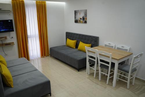 a living room with a couch and a table and chairs at Apartments Costa Azzurra in Velipojë