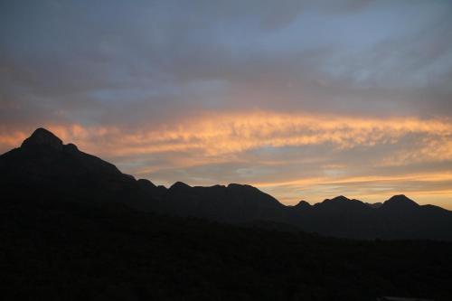 a sunset over a mountain range with mountains in the background at umVangati House in Hoedspruit