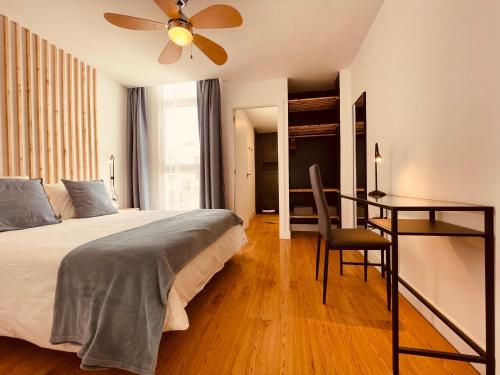 1 dormitorio con cama, escritorio y ventilador de techo en Cozy apartments and deluxe lofts in Fuerteventura, en Cotillo