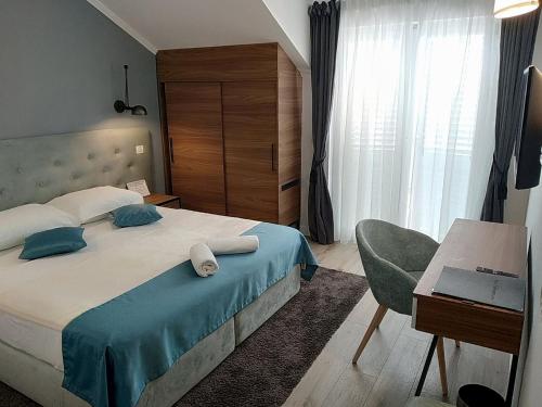 a bedroom with a bed with a desk and a chair at Hotel Perla in Dubrovnik