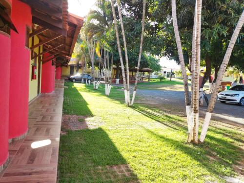 a row of palm trees next to a building at Pousada Voo das Garças in Bonito